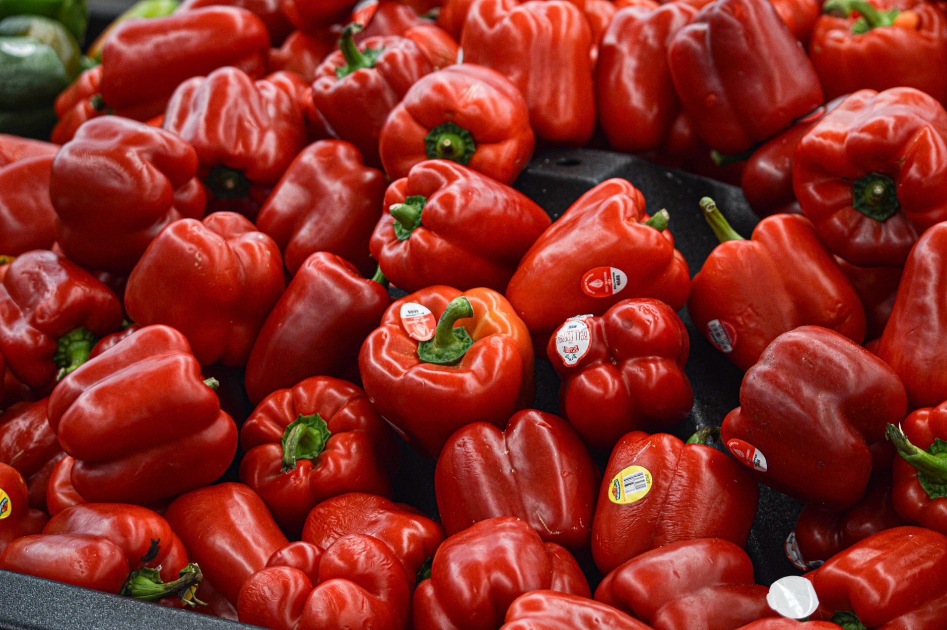 Un vibrante montón de pimientos rojos frescos en un entorno de mercado, ideal para temas de comida y estilo de vida.