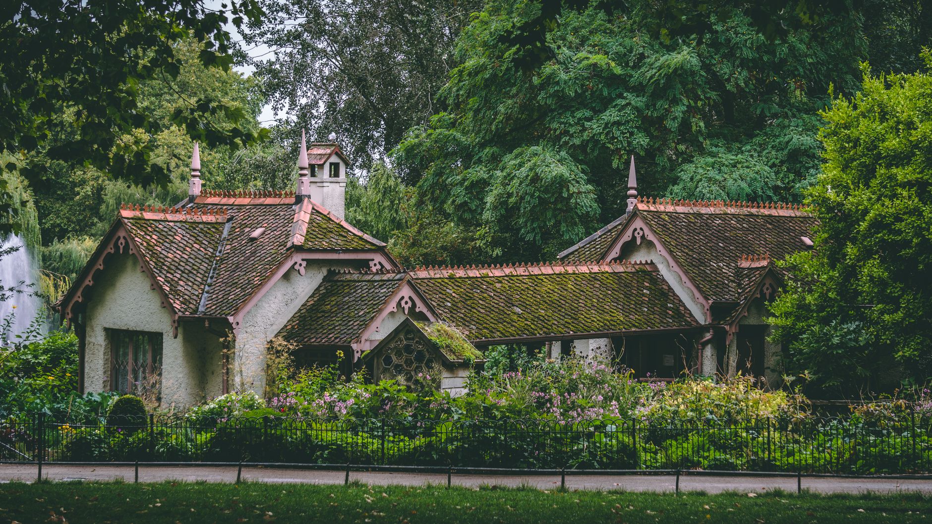 Encantador bungalow de estilo gótico situado en un exuberante jardín londinense rodeado de un vibrante follaje.